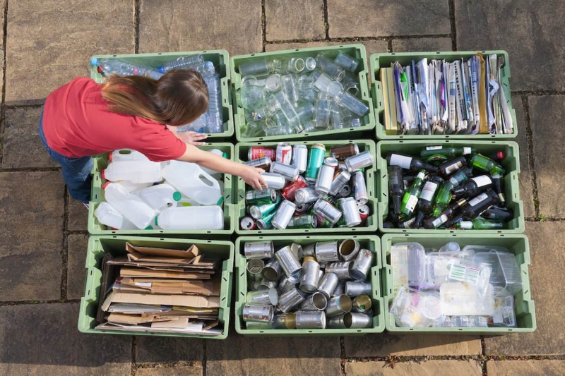 دختری که سطل های بازیافت را سازماندهی می کند